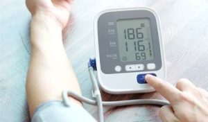 Un uomo misura la sua pressione sanguigna con un misuratore - la lettura è troppo alta