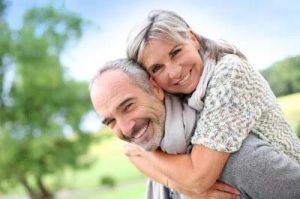 Una coppia vitale di 60 anni, che sorride felicemente alla telecamera, irradiando contentezza e salute.