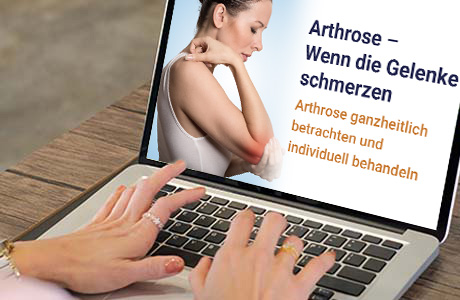 Frauenhände auf der Tastatur eines Laptops - auf dem Bildschirm ist eine Fachinformation zum Thema Arthrose zu sehen
