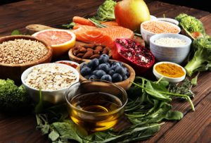 Aufnahme von gesunden Lebensmitteln, wie Salat, Brokkoli, Tomaten, Pilzen, Möhren - arrangiert auf einem Holzbrett